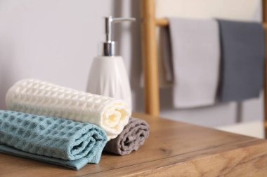 Temiz waffle havluları ve ahşap şifoniyerde el sabunu, yakın plan. Metin için boşluk