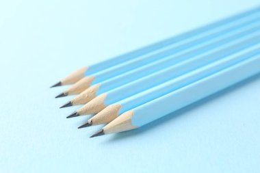 Açık mavi arkaplanda çizgili kalemler, yakın plan