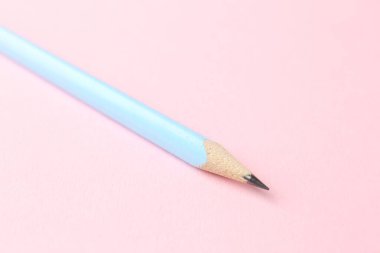 Pembe arka planda bir grafit kalem, yakın plan.