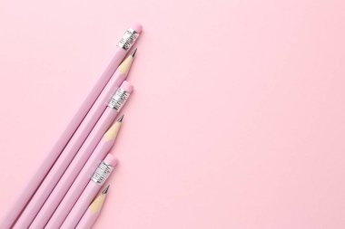 Pembe arka planda bir sürü grafit kalem var. Metin için boşluk