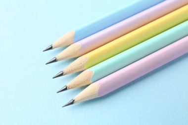 Açık mavi arkaplan üzerinde birçok grafit kalem, yukarıda görünüm