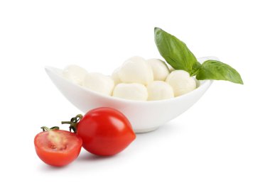 Beyaz arka planda lezzetli mozzarella peynir topları, domates ve fesleğen.