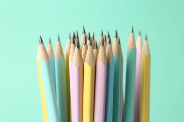 Turkuaz arka planda birçok grafit kalem, yakın plan