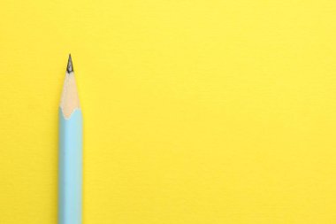 Sarı arka planda bir grafit kalem, en üstte. Metin için boşluk