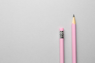 Açık gri zemin üzerinde iki grafit kalem, düz zemin. Metin için boşluk