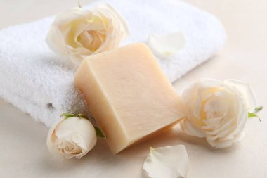 Aromatik sabun çubuğu ve güller ışık masasında.