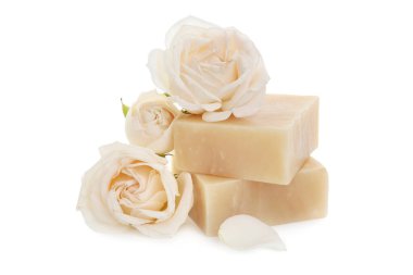 Aromatik sabun çubukları ve beyaza izole güller.