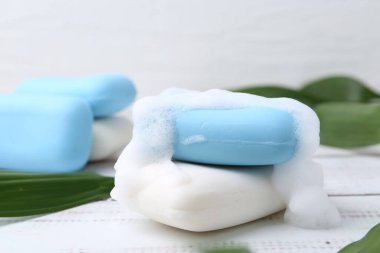 Köpüklü sabun çubukları beyaz ahşap masa, yakın plan.