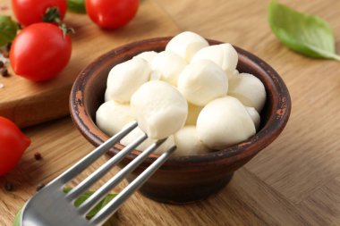 Ahşap masa çatallı mozzarella topunu alıp yakın plan çekiyoruz.