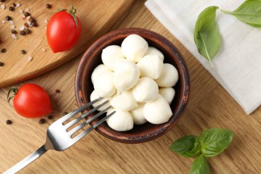 Lezzetli mozzarella topları, domatesler, biberler ve fesleğenler ahşap masada, düz yatıyordu.