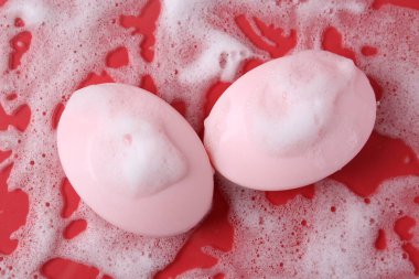 Kırmızı arka planda köpüklü sabun çubukları, düz yatış