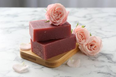 Sabun çubukları ve beyaz mermer masada güzel güller, yakın plan.