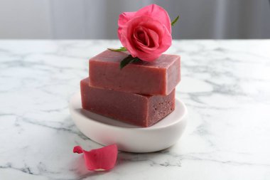 Sabun çubukları ve beyaz mermer masada güzel bir gül, yakın plan.