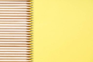 Sarı arka planda bir sürü grafit kalem var. Metin için boşluk