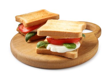 Beyaz arka planda peynirli, domatesli ve fesleğenli lezzetli sandviçler.