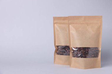 Açık gri arka planda kahve çekirdekli fermuar stand-up torbaları. Tasarım için model