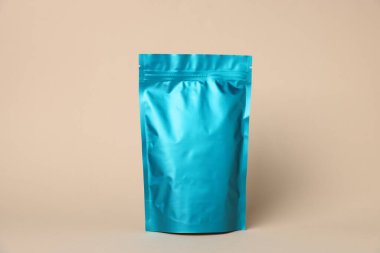 Bej arka planda fermuarlı bir stand-up kesesi. Tasarım için model