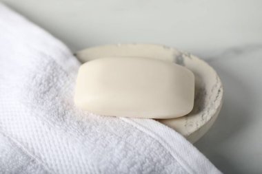 Beyaz mermer masanın üstünde sabun çubuğu ve havlu var.