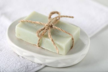 Sabun çubuğu ve havlu beyaz masada, yakın plan.