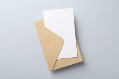 Açık gri arkaplanda boş davetiye ve zarf, üst görünüm