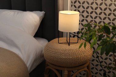 Yan masada yatağın yanında lamba var.