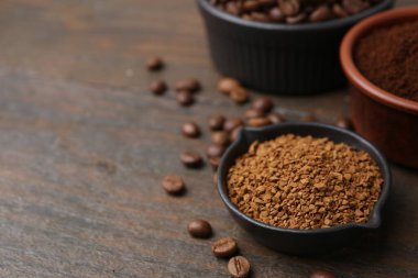 Tahta masadaki kaselerde farklı kahve ve fasulye türleri, yakın plan. Metin için boşluk