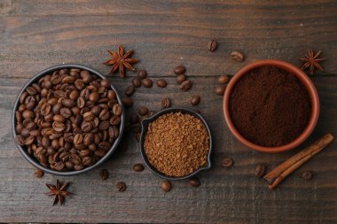 Farklı türde hazır kahve, fasulye ve baharatlar ahşap masada, düz yerde.