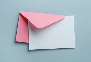 Gri arka planda boş davetiye ve zarf, üst manzara. Tasarım için boşluk