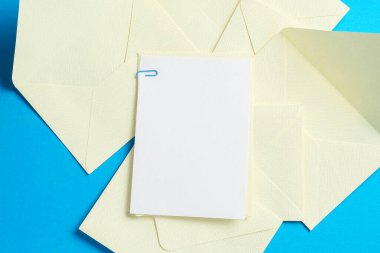 Açık mavi arka planda boş davetiye ve zarflar. Tasarım için boşluk