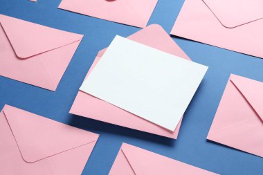 Mavi arkaplanda boş davetiye ve zarflar var. Tasarım için boşluk