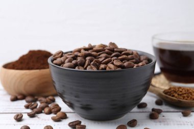 Kavrulmuş fasulye ve beyaz ahşap masada değişik türde hazır kahve.