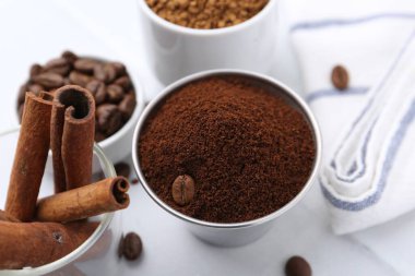 Anında kahve tozu, fasulye ve tarçın çubukları ışık masasında, yakın plan.