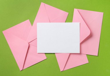 Boş davetiye kartı ve yeşil arka planda zarflar. Tasarım için boşluk