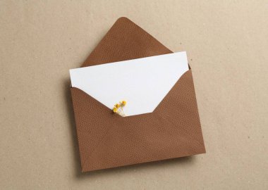 Kutu üzerinde çiçekler ve zarf olan boş davetiye kartı, üst görünüm