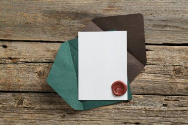 Üzerinde balmumu mühür ve ahşap masa manzaralı boş bir davetiye kartı. Tasarım için boşluk