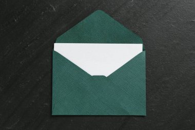 Siyah masada boş davetiye ve zarf, üst görünüm