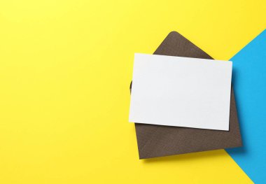 Renk arkaplan üzerinde boş davetiye ve zarf, üst görünüm. Tasarım için boşluk