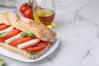 Mozarella peynirli, domatesli, fesleğenli, beyaz mermer masaya yakın çekim. Metin için boşluk