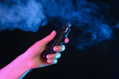 Siyah arka planda neon lambalarda elektronik sigara içen kadın, yakın plan