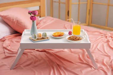 Nefis bir kahvaltı tepsisi ve kapalı bir odada çiçekler.