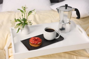 Nefis bir kahvaltı tepsisi ve kapalı bir odada çiçekler.