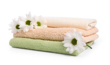 Yumuşak havlular ve beyaza izole edilmiş kasımpatı çiçekleri.