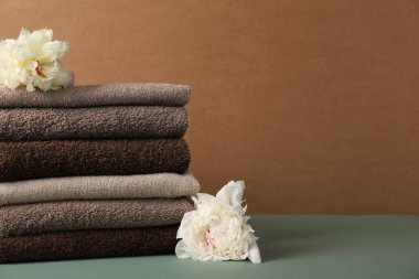 Renkli arka planda bir yığın yumuşak havlu ve şakayık çiçeği, yakın plan. Metin için boşluk