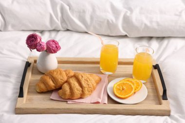 Nefis bir kahvaltı tepsisi ve çiçeklerle kapalı bir yerde, yakın plan.