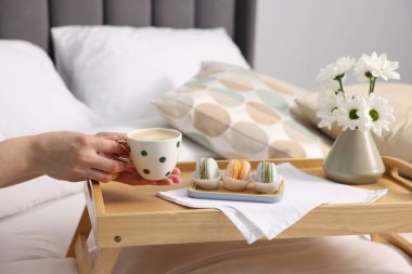 Kadın yatakta nefis bir kahvaltı yapıyor, yakın plan.