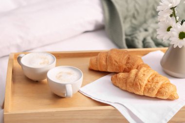 Nefis bir kahvaltı tepsisi ve kapalı bir odada çiçekler, yakın plan. Metin için boşluk