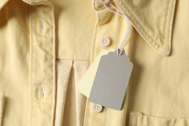 Soluk sarı gömlekte karton etiketler, üst manzara.