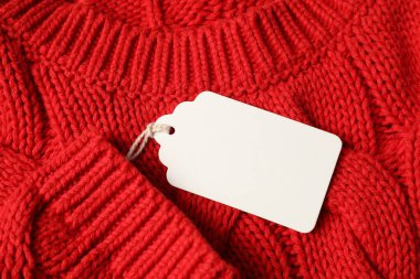 Kırmızı örgü süveter üzerindeki karton etiket, üst görünüm