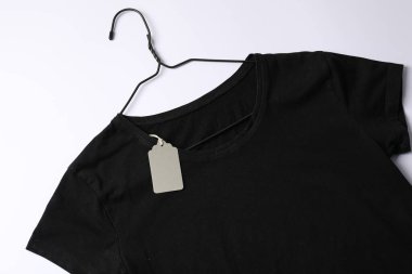 Beyaz arkaplanda etiketli tişört, üst görünüm