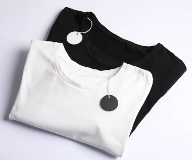 Beyaz arkaplanda etiketli tişörtler, üst görünüm